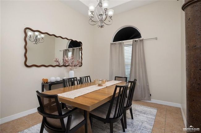 Dining space featuring light tile patterned floors and a chandelier | Image 4