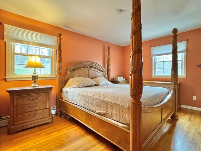 Bedroom with baseboards, light wood-type flooring, and a baseboard radiator | Image 18
