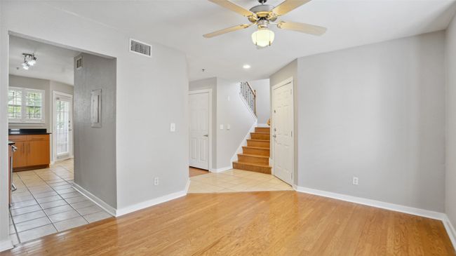 Unfurnished room with ceiling fan, stairway, light wood-style floors, and baseboards | Image 10