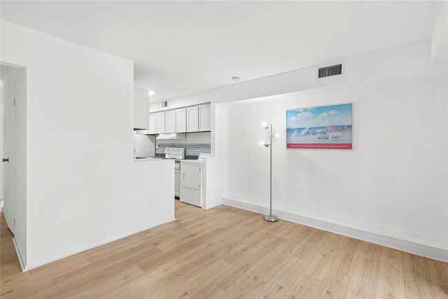 Unfurnished living room featuring visible vents, light wood-style flooring, washer / clothes dryer, and baseboards | Image 4