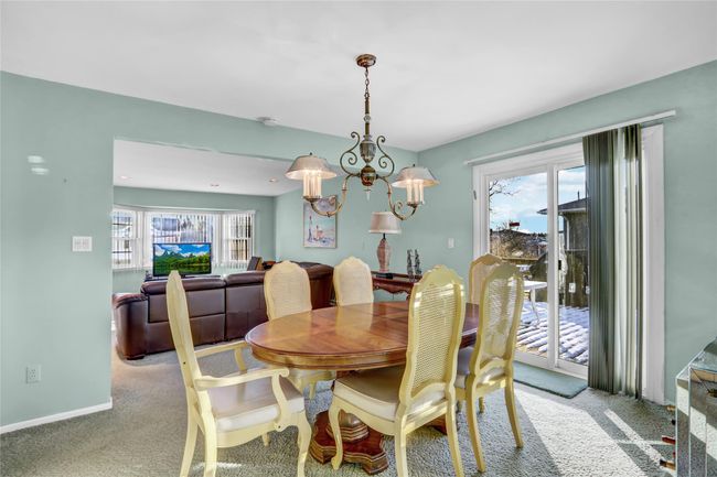 Dining area with an inviting chandelier, a healthy amount of sunlight, and light carpet | Image 10