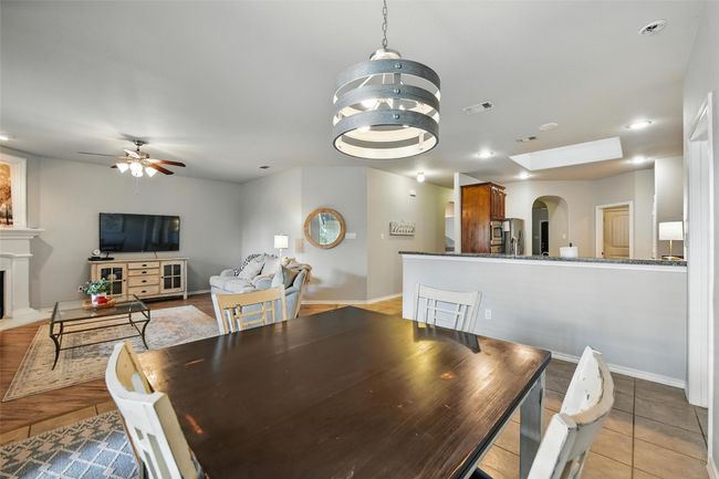 Dining space with arched walkways, a fireplace, a ceiling fan, recessed lighting, and a chandelier | Image 27