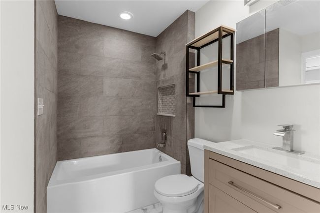 Full bathroom featuring vanity, shower / bathtub combination, marble look tiles, and recessed lighting | Image 18