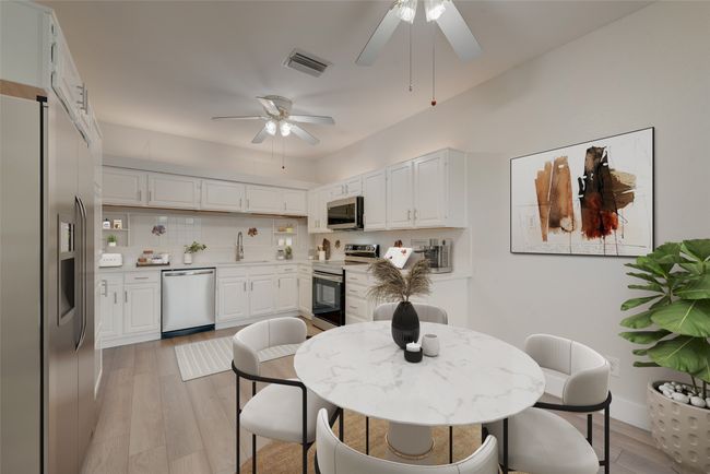 Kitchen with stainless steel appliances, ceiling fan, and white cabinets | Image 6