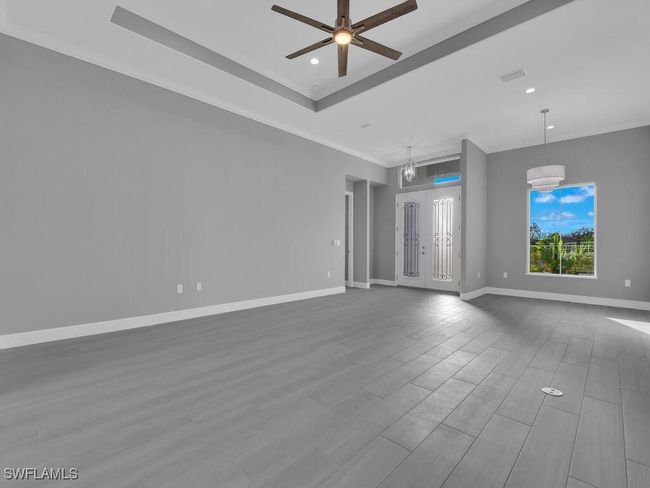 Spare room with ornamental molding, a ceiling fan, recessed lighting, wood finished floors, and a tray ceiling | Image 9