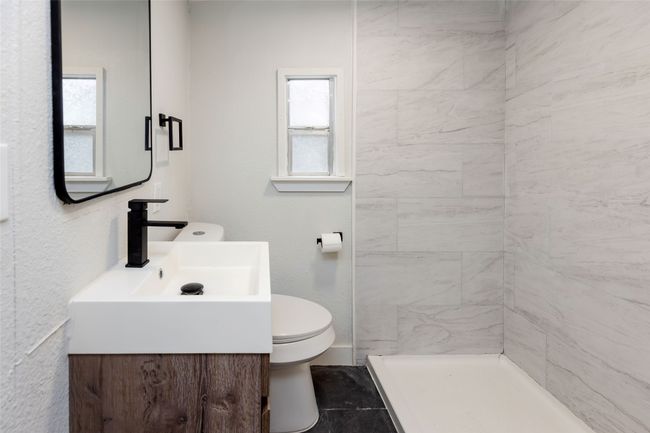 Full bath featuring vanity, toilet, and tiled shower | Image 5