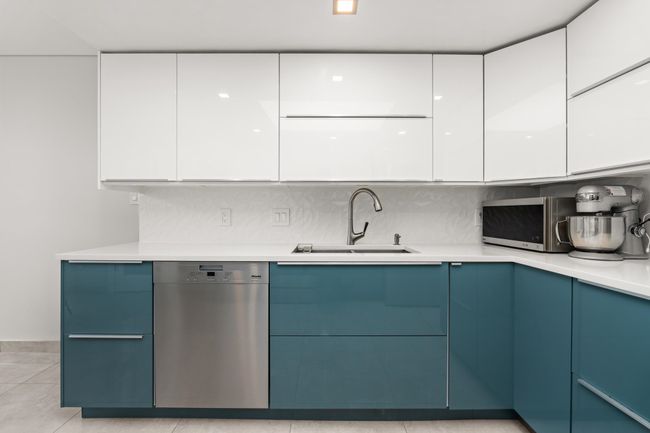 Kitchen featuring light countertops, modern cabinets, appliances with stainless steel finishes, white cabinetry, and a sink | Image 18
