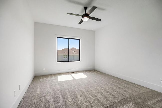 Carpeted spare room featuring a ceiling fan and baseboards | Image 15