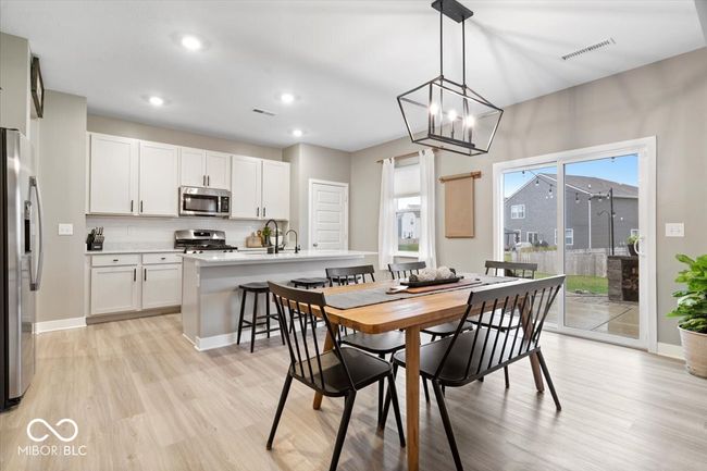 dining area featuring light wood finished floors, a chandelier, and recessed lighting | Image 16