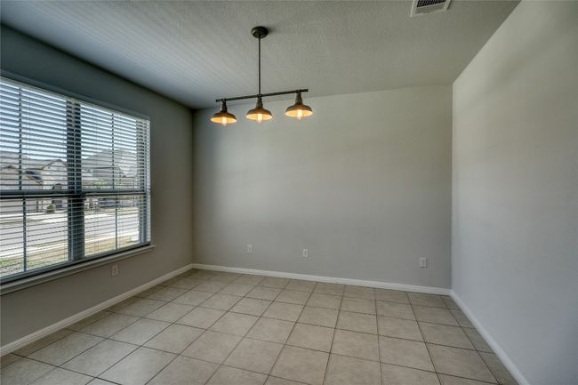 Unfurnished room with visible vents, track lighting, baseboards, light tile patterned floors, and a textured ceiling | Image 7