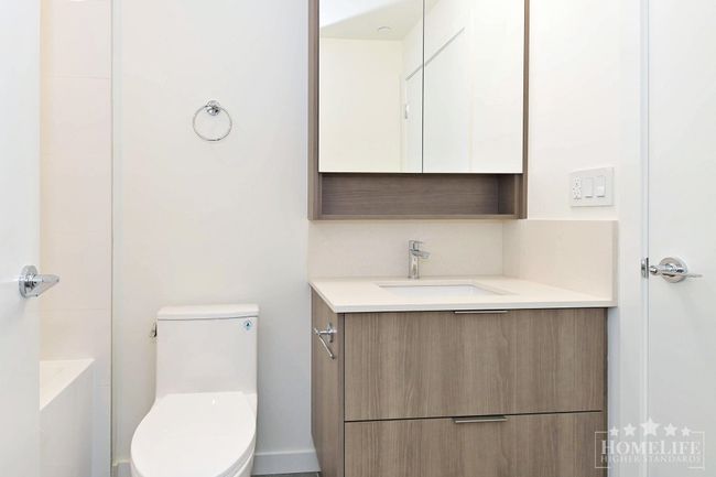 Full bathroom with toilet, vanity, and a shower | Image 9