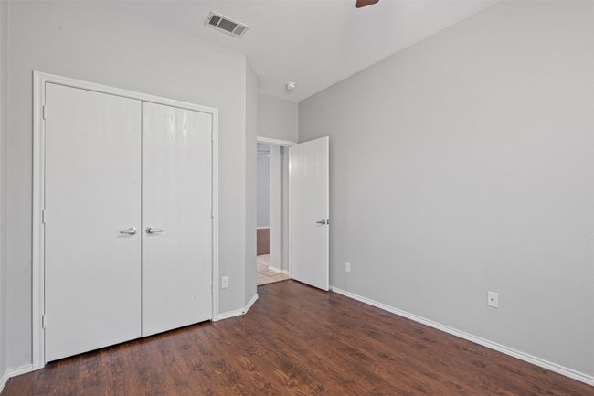 Unfurnished bedroom with wood finished floors, a closet, and a ceiling fan | Image 8