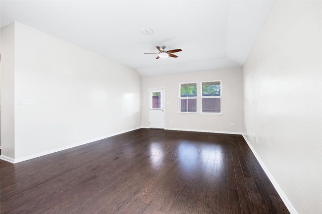 Empty room featuring ceiling fan and dark wood-style floors | Image 22