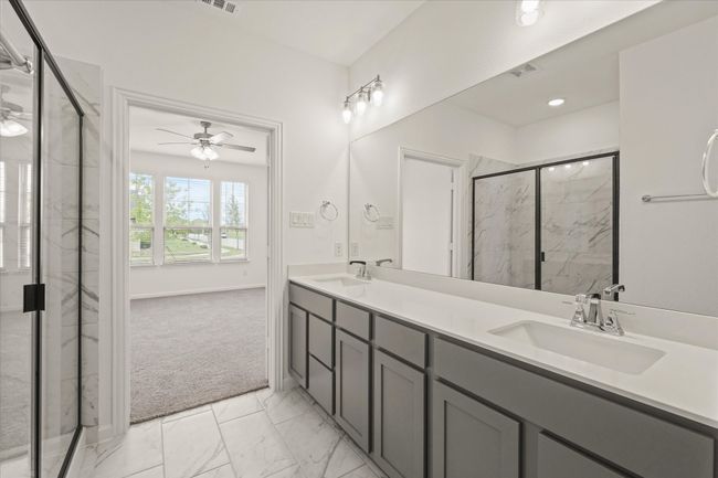 Bathroom featuring ceiling fan, a marble finish shower, marble finish floors, and double vanity | Image 10