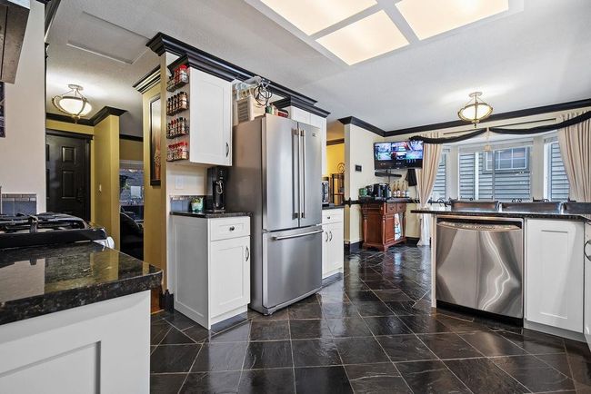 Kitchen with appliances with stainless steel finishes, crown molding, white cabinetry, and baseboards | Image 9