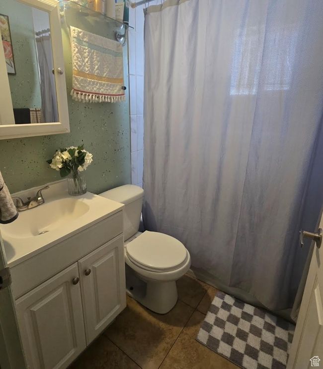 Bathroom featuring curtained shower, tile patterned floors, vanity, and toilet | Image 15