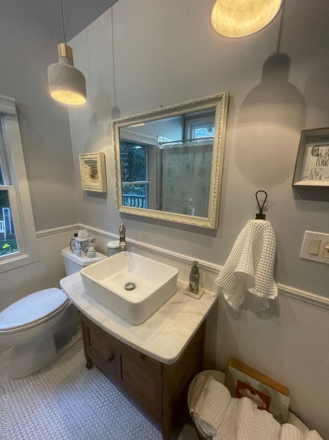 Bathroom featuring wainscoting, vanity, a shower, and a decorative wall | Image 12