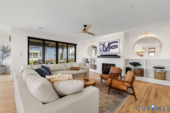 Living room with light wood-style floors, a large fireplace, a ceiling fan, and recessed lighting | Image 5