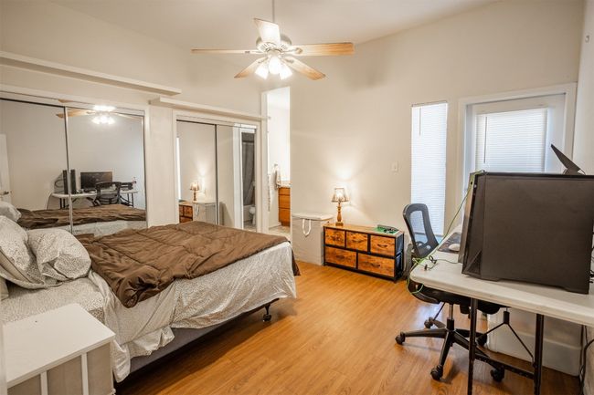 Bedroom featuring light wood-type flooring, an office area, and ceiling fan | Image 9