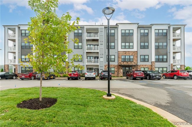 View of apartment building / complex featuring uncovered parking | Image 38