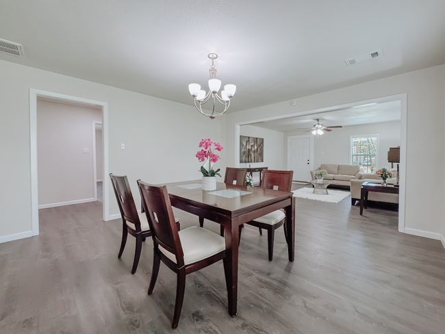 Dining room featuring wood finished floors, a chandelier, and a ceiling fan | Image 8