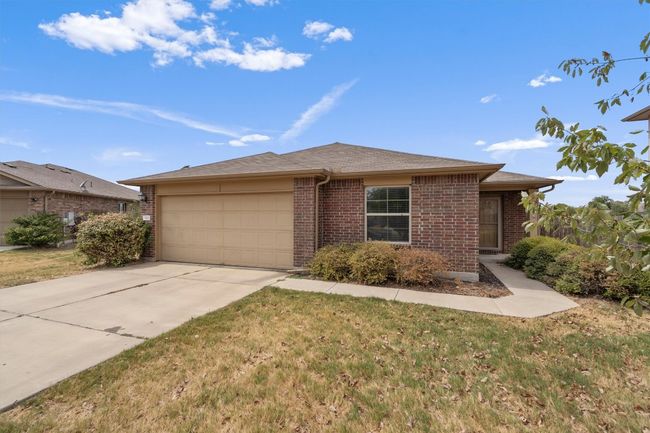 Old exterior photo of home during drought--during zero watering days. View of front of home with brick siding, an attached garage, driveway, a front lawn, and a shingled roof | Image 30