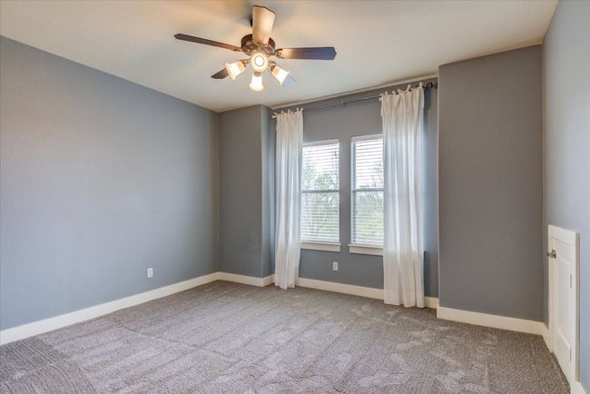 Bedroom with walk-in closet, carpet flooring, a ceiling fan | Image 29