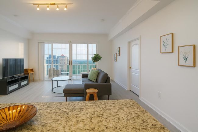 Living area with wood finished floors and crown molding | Image 7