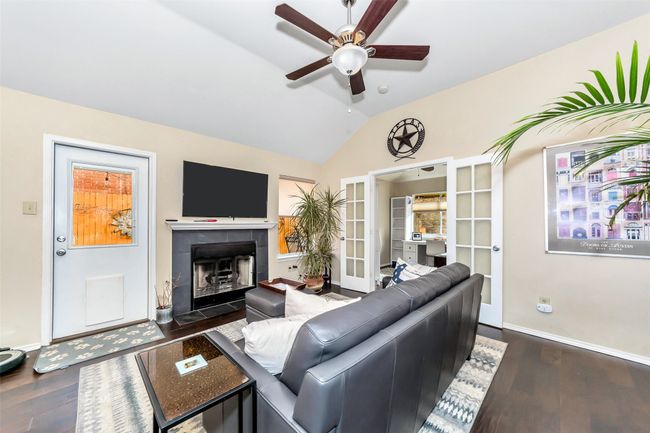 Living area featuring lofted ceiling, ceiling fan, french doors, wood finished floors, and baseboards | Image 11