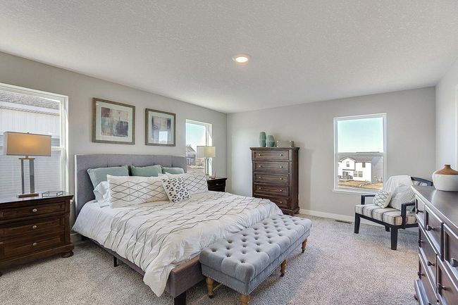 An oasis on it's own, the primary suite is both open and expansive, overlooks the back and is connected to a spacious primary suite bath and an oversized walk-in closet. Photo of model home, color and options will vary. | Image 13