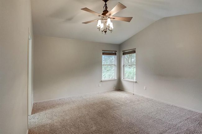 Spare room featuring vaulted ceiling, carpet, a ceiling fan, and baseboards | Image 18