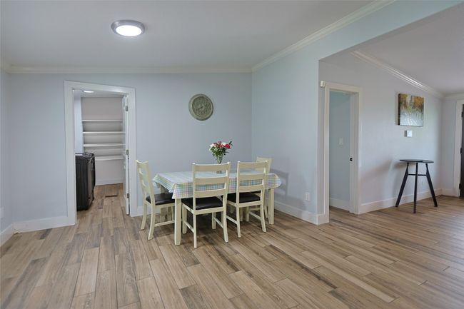 Dining room with baseboards, ornamental molding, and light wood-style flooring | Image 8