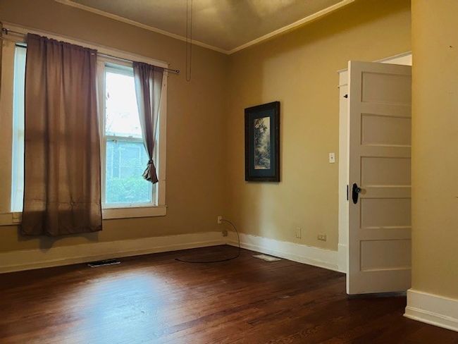 Empty room with crown molding, dark wood-type flooring, and baseboards | Image 13