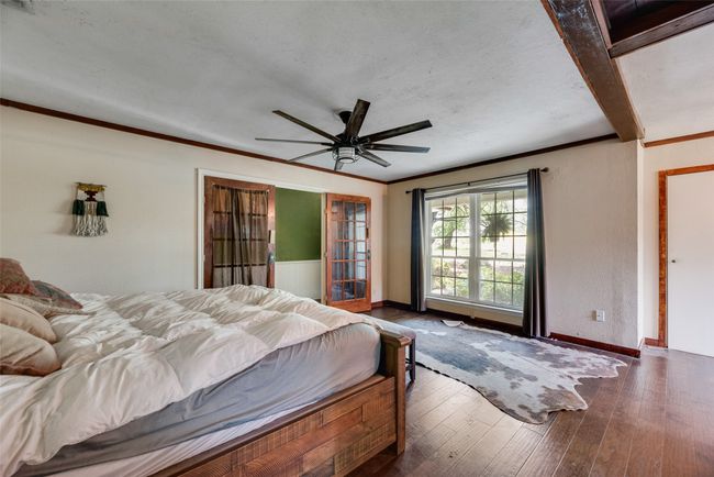Bedroom with wood-type flooring, a ceiling fan, baseboards, and ornamental molding | Image 16