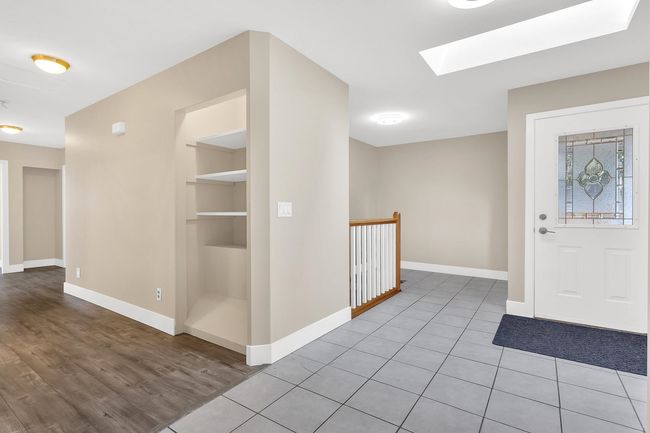 Foyer featuring light tile patterned floors, a skylight, and baseboards | Image 21