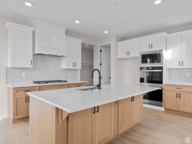 Kitchen featuring a sink, a center island with sink, and white cabinetry | Image 9