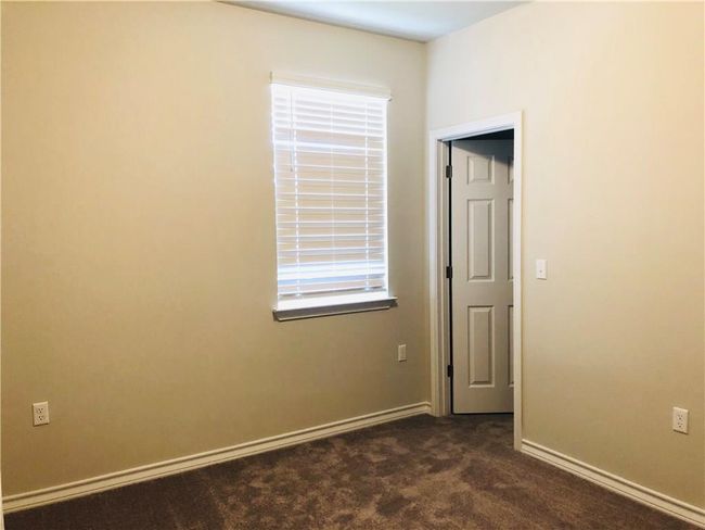 Spare room featuring dark colored carpet and healthy amount of natural light | Image 9