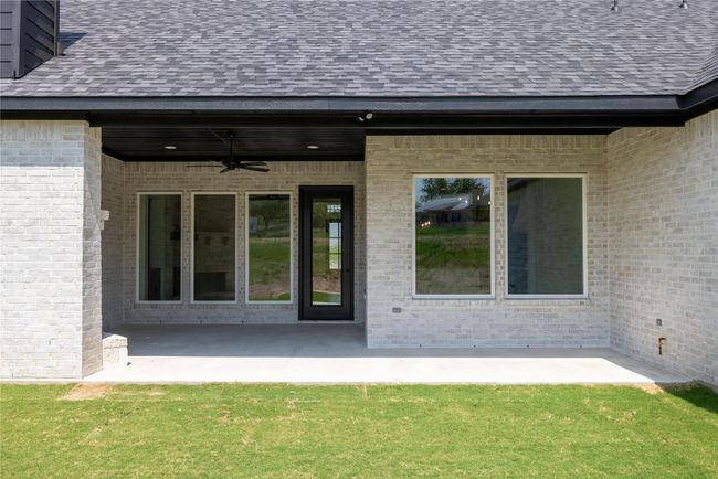 Property entrance with ceiling fan, a patio area, and a lawn | Image 36
