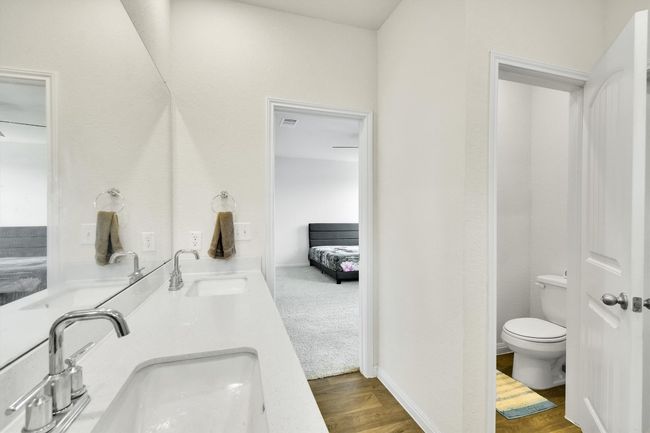Bathroom with toilet, double vanity, and wood finished floors | Image 18