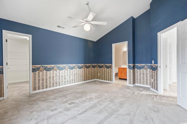 Carpeted spare room with a ceiling fan and high vaulted ceiling | Image 18