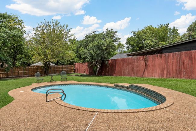 View of swimming pool featuring a fenced backyard and a patio | Image 33