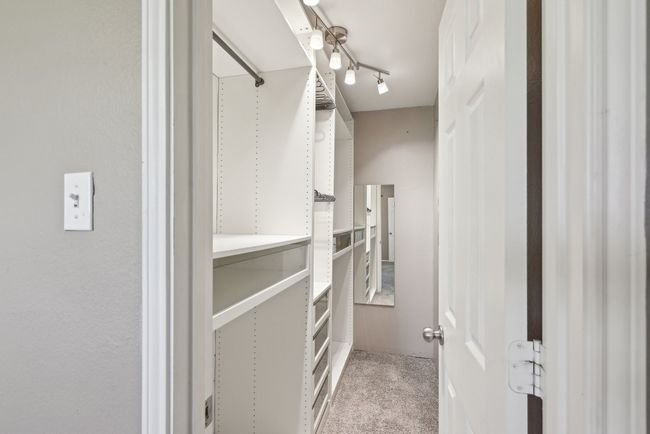 Walk in closet with light carpet | Image 25
