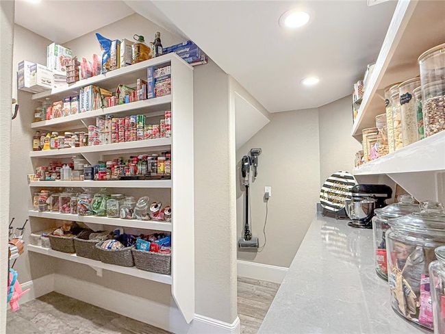 This oversized walk-in pantry is truly a once-in-a-lifetime find. It’s thoughtfully designed with custom shelving and cabinets that provide ample storage for all your kitchen essentials. The sleek quartz countertops offer extra prep space, while additional storage areas ensure that everything has its place. With its functional layout and high-end finishes, this pantry is not just a storage space—it’s a luxurious, organized haven for all your food and kitchen supplies. | Image 32