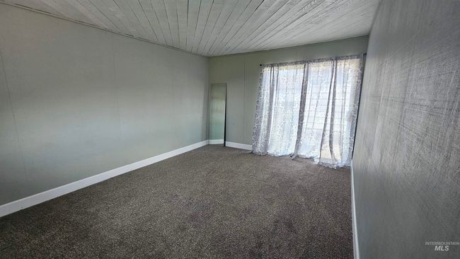 Unfurnished room with dark carpet and wood ceiling | Image 16