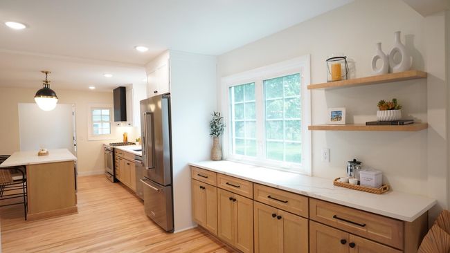 The modern organic design of this upscale kitchen is both welcoming and impressive. It offers a ton of light and storage, matte black hardware and floating shelves. | Image 4