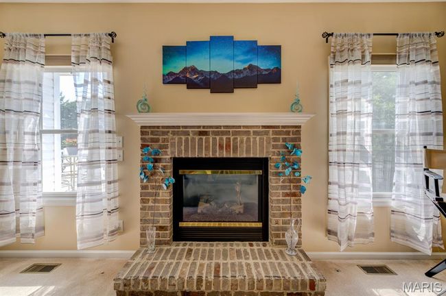 ...and situates toward the beautiful fireplace, flanked by two windows to let in natural light. | Image 7
