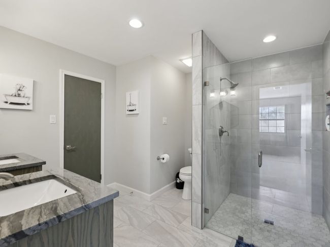 Full bath with vanity, toilet, marble finish floor, a stall shower, and baseboards | Image 24