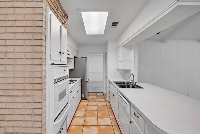 Kitchen featuring visible vents, a sink, white appliances, a warming drawer, and white cabinetry | Image 12