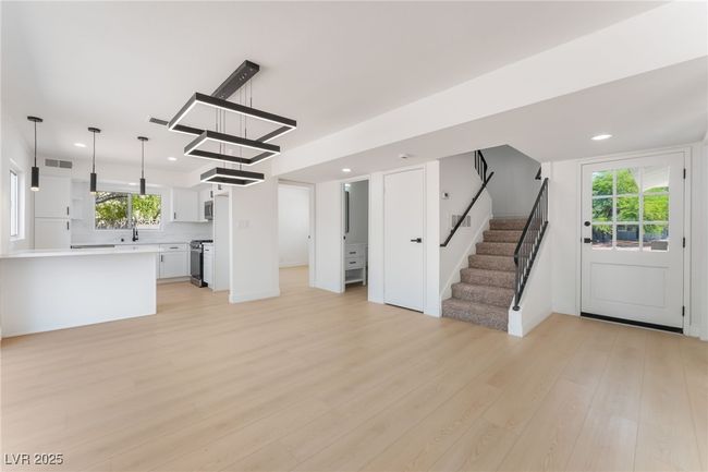 Unfurnished living room with light wood-style flooring, stairs, and recessed lighting | Image 12