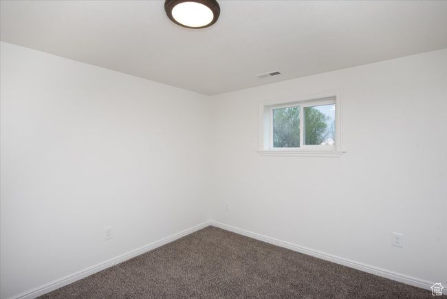 Empty room featuring baseboards, dark colored carpet, and visible vents | Image 27